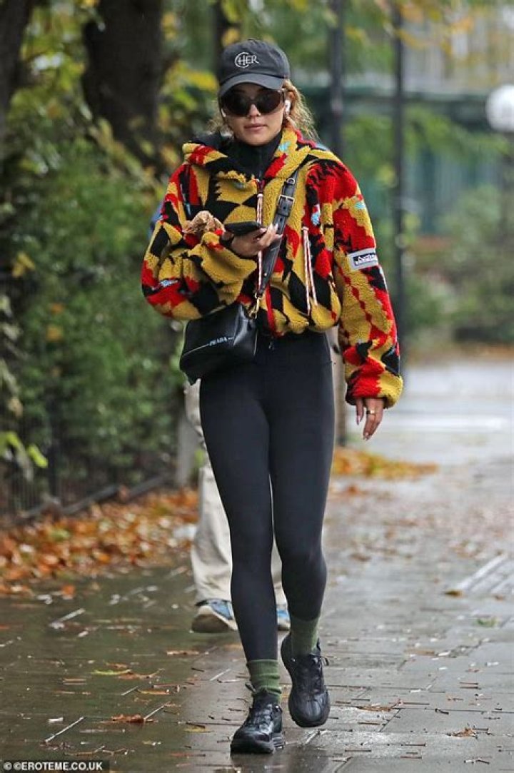 Rita Ora dons a colourful zipup fleece and black leggings as she steps